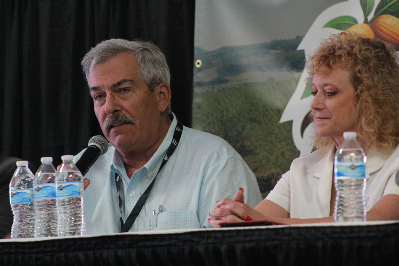 Two Almond Day panelists discuss the industry at microphones in 2026.