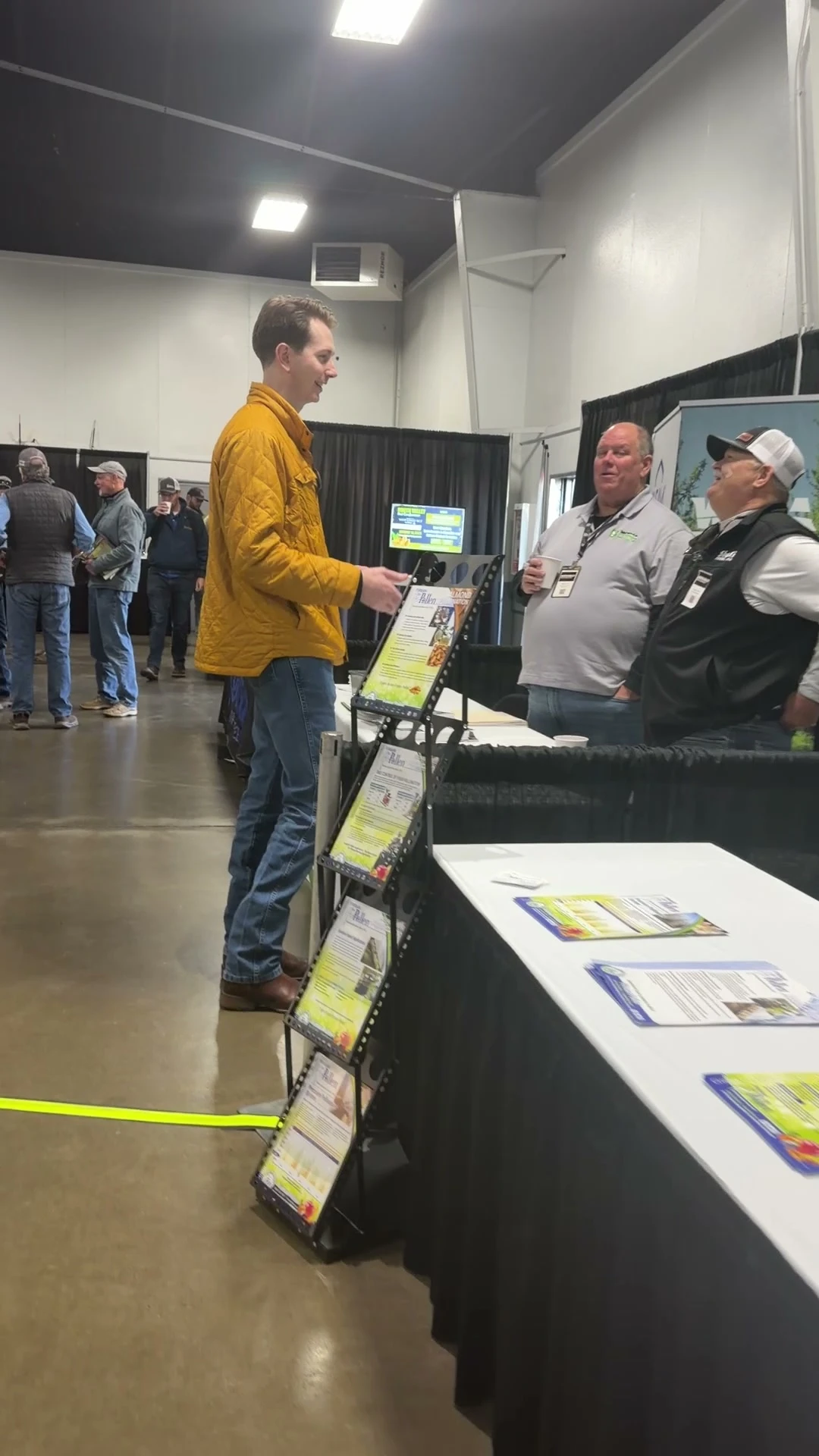 Three people talk beside an exhibitor display at North Valley Nut Conference in 2026.